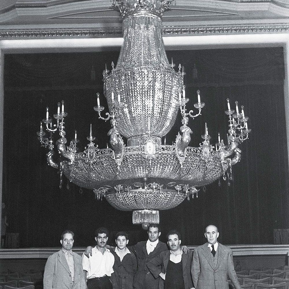 La làmpara al pati de butaques del teatre quan fou penjada en 1952. El primer de la dreta és l'artista que la dissenyà, Enrique Mariner Saurí. 